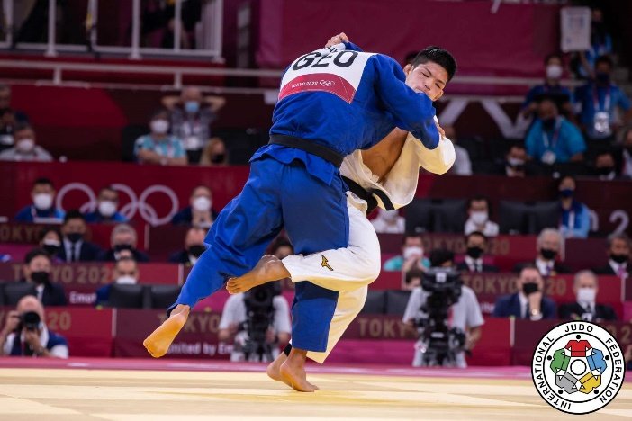 Dos judokas en posición de combate cercano durante una fase de ataque en el tatami.