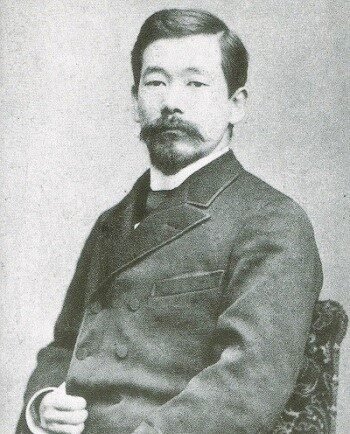 Retrato fotográfico en blanco y negro de Jigoro Kano de joven con traje occidental de época y bigote.
