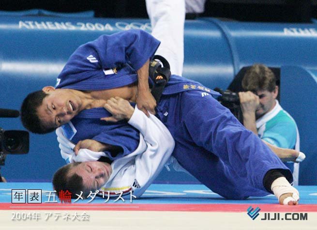 El judoka Tadahiro Nomura manteniendo el control posicional en el suelo (Ne-waza) durante una transición en los Juegos Olímpicos de Atenas 2004.