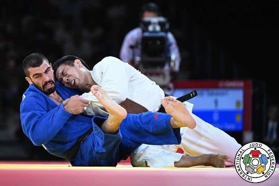 El judoka Takanori Nagase en una fase de combate de suelo (Ne-waza) presionando a su oponente con judogi azul.