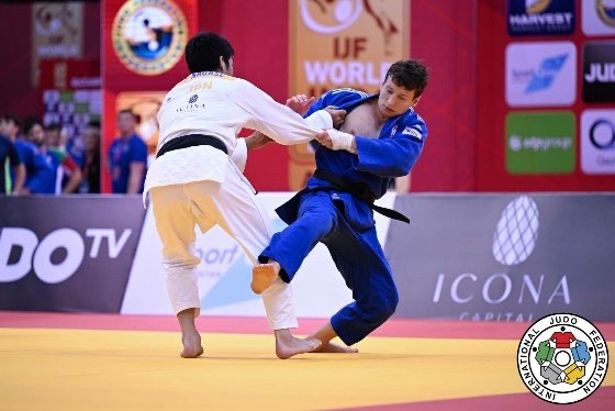 El judoka Takanori Nagase con judogi blanco disputando un agarre de solapa y manga (Kumi-kata) frente a un rival con judogi azul durante el World Judo Tour.