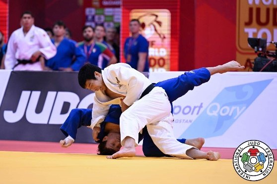 Takanori Nagase completando una proyección baja a ras de lona sobre su oponente durante una competencia oficial de judo.