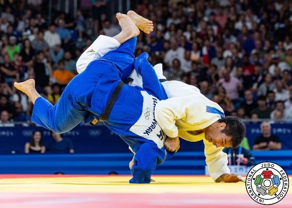Takanori Nagase completando la proyección de sacrificio (Sutemi-waza) sobre Vedat Albayrak en el tatami olímpico.