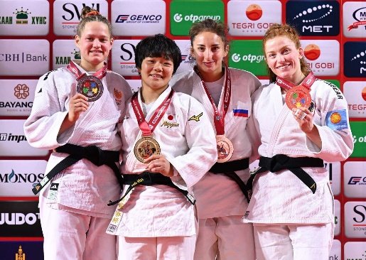 "La judoka japonesa Haruka Funakubo en el centro del podio sosteniendo su medalla de oro junto a las demás medallistas de la categoría internacional.