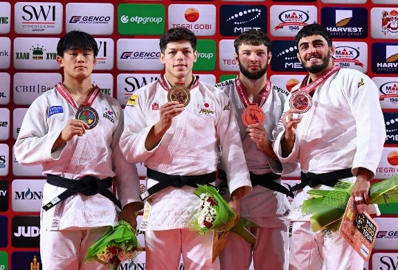 El judoka japonés Sanshiro Murao en el centro del podio sosteniendo su medalla de oro junto a los competidores de Corea del Sur, Georgia y Uzbekistán.