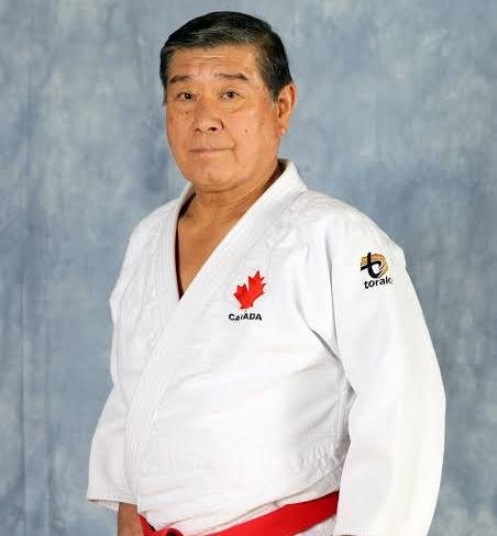Retrato de estudio del maestro Hiroshi Nakamura con judogi blanco de Judo Canada y cinturón rojo de alto grado.