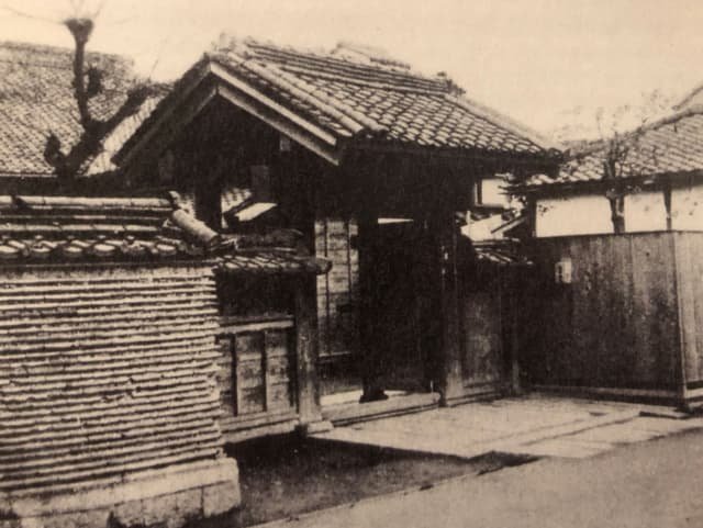 Fotografía histórica en blanco y negro del portal de entrada de arquitectura tradicional japonesa del templo Eisho-ji, sede original del primer Kodokan en 1882.